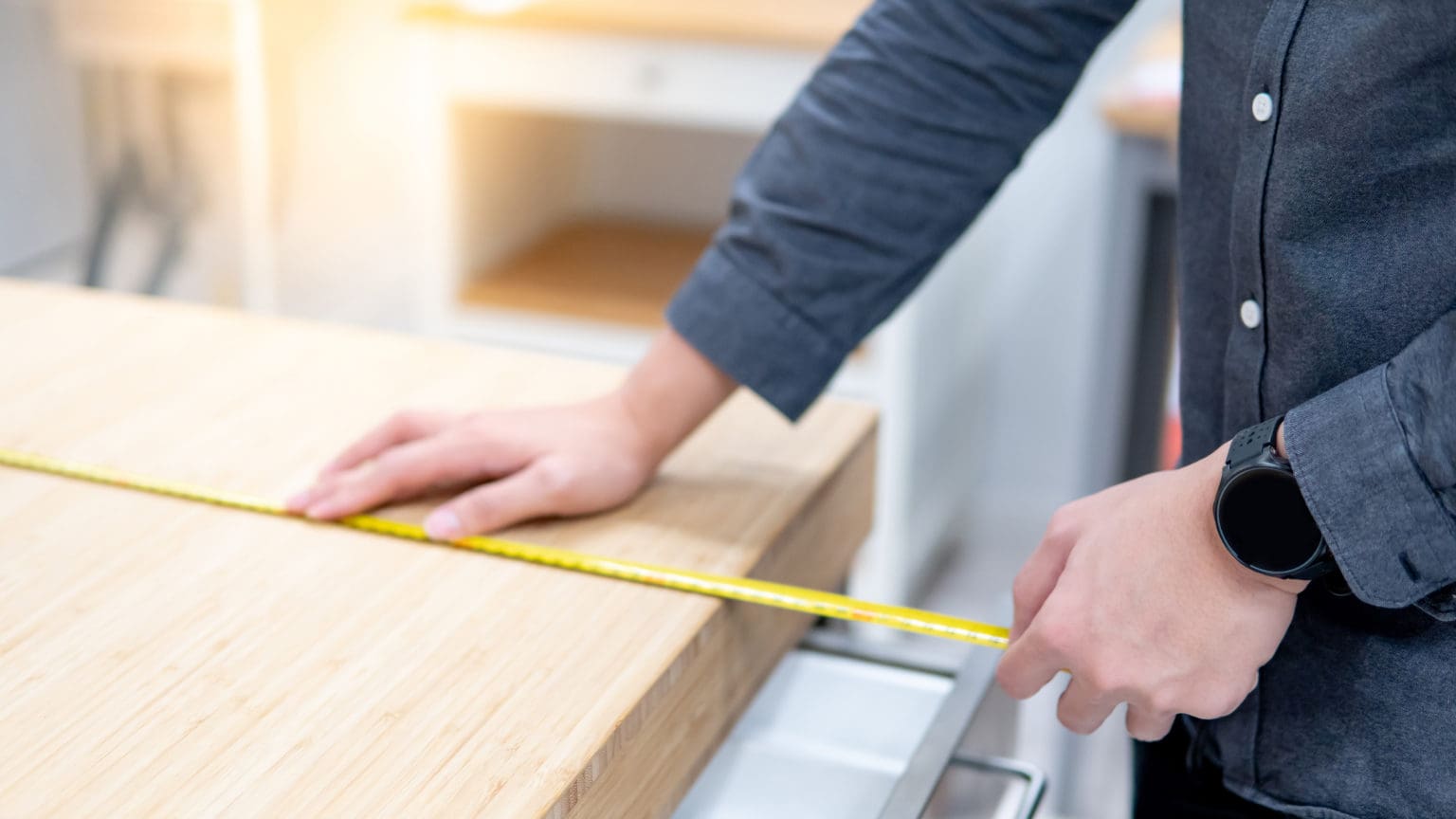 Kitchen renovation contractor measuring cabinets during installation in Malaysian home